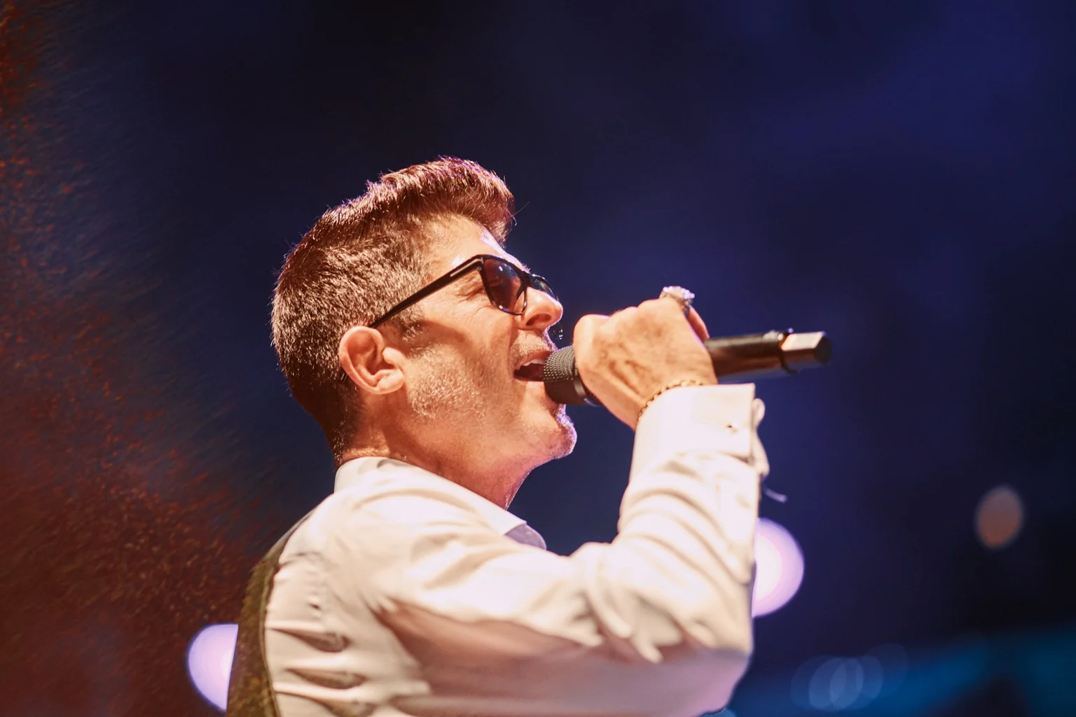 Singer performing under warm concert lighting