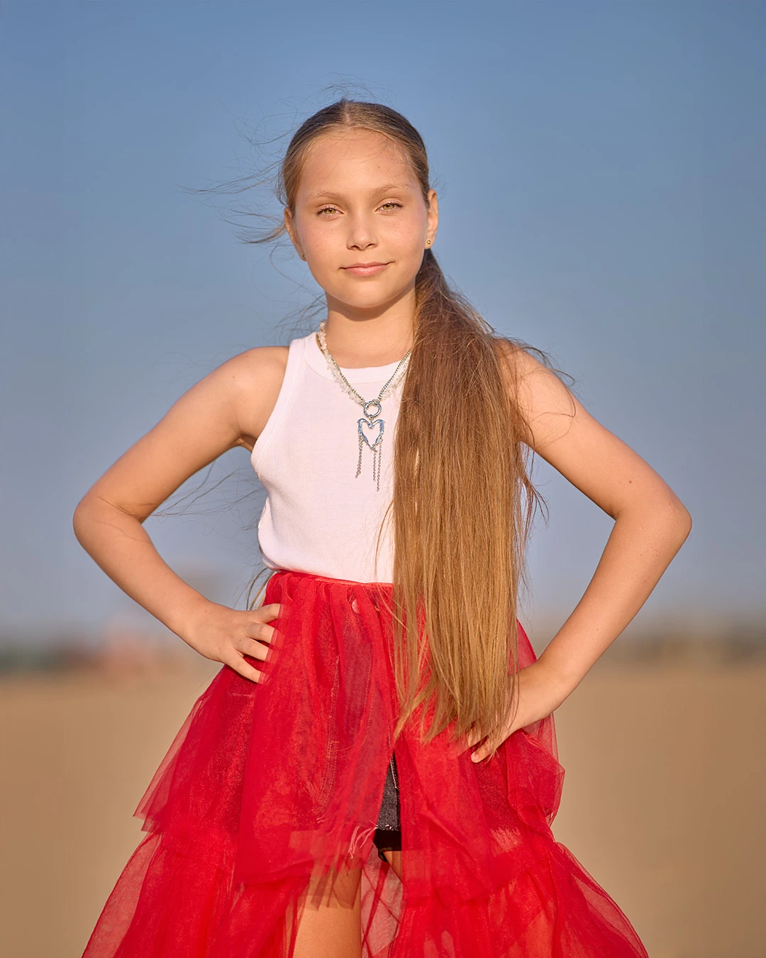 Young model in a white top and red tulle skirt outdoors